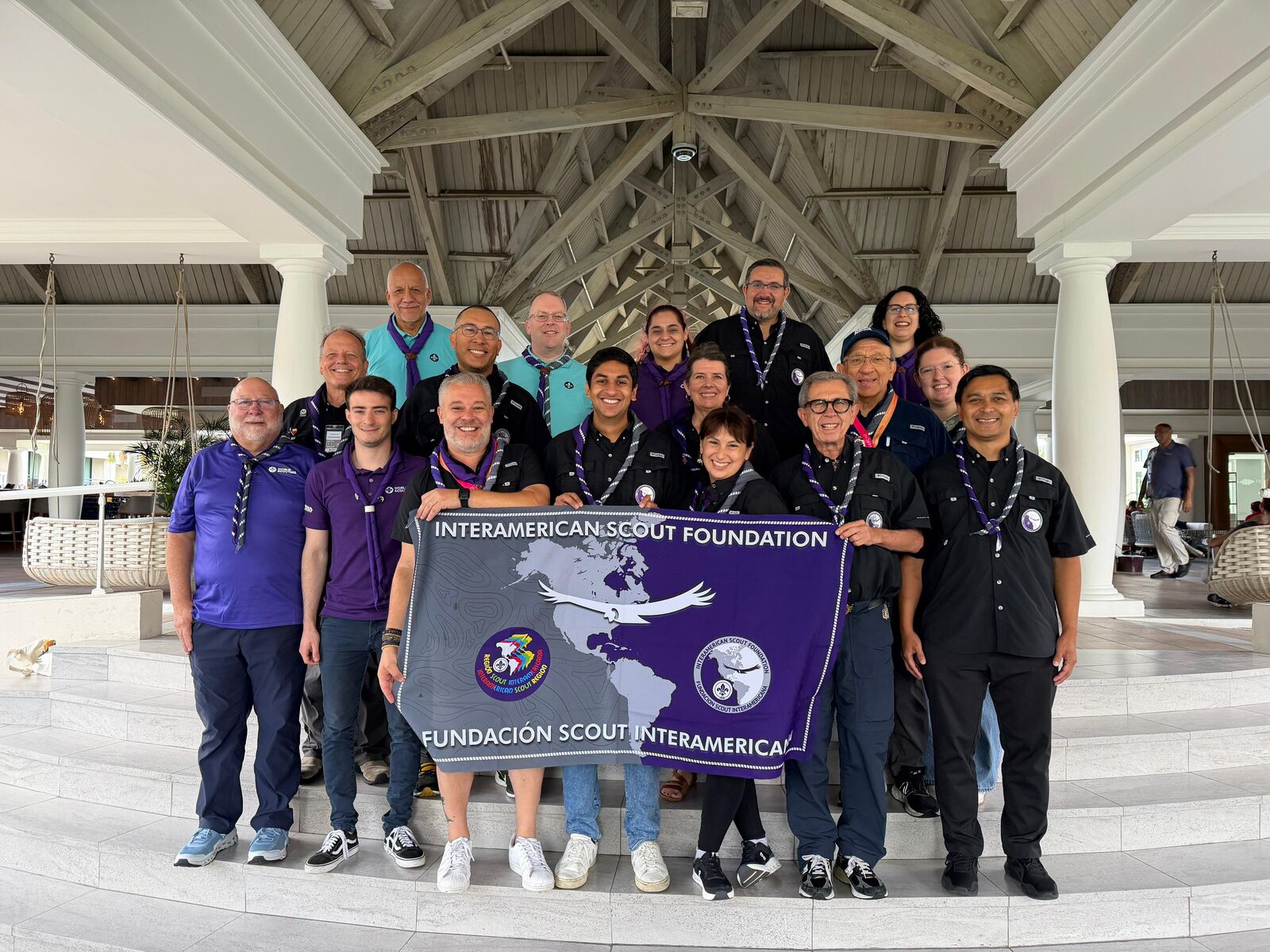 The IASF delegation holding the Interamerican Scout Foundation banner under the timber roof of the conference venue in Curaçao